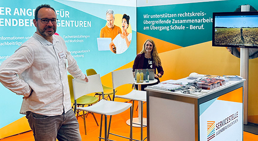 Zwei Mitarbeitende der Servicestelle am Messestand