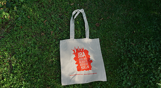 Heller Stoffbeutel  mit orangefarbenem Logo der Jugendberufsagentur Kln