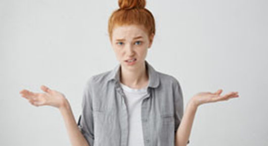 Eine junge Frau macht eine Geste der Ratlosigkeit und hat einen unzufriedenen Gesichtsausdruck. Eine junge Frau macht eine Geste der Ratlosigkeit und hat einen unzufriedenen Gesichtsausdruck.